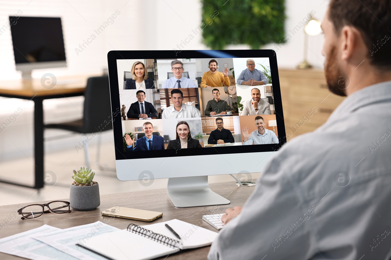 Image of Business meeting. Man using computer during online video chat at table, closeup