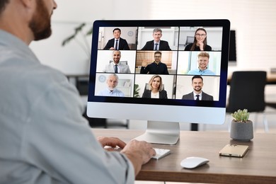 Business meeting. Man using computer during online video chat at table, closeup