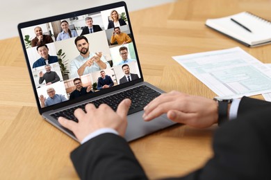 Image of Business meeting. Man using laptop during online video chat at table, closeup