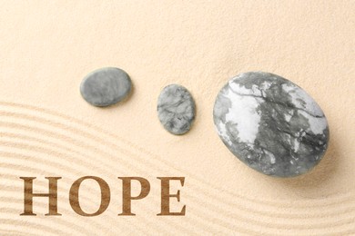 Image of Hope. Zen garden stones on sand with pattern, top view