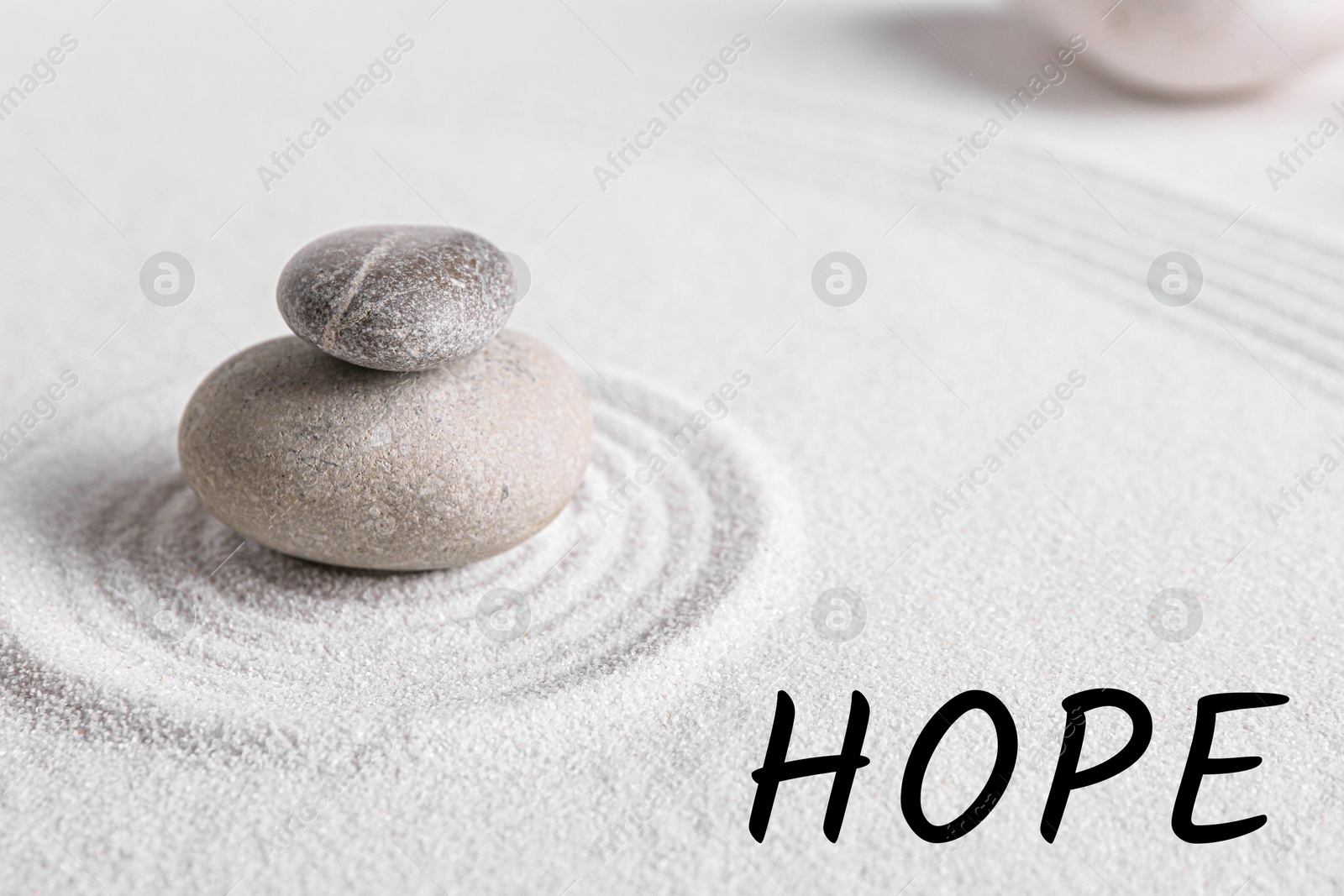 Image of Hope. Zen garden stones on white sand with pattern