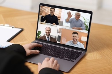 Image of Business meeting. Woman using laptop during online video chat at table, closeup