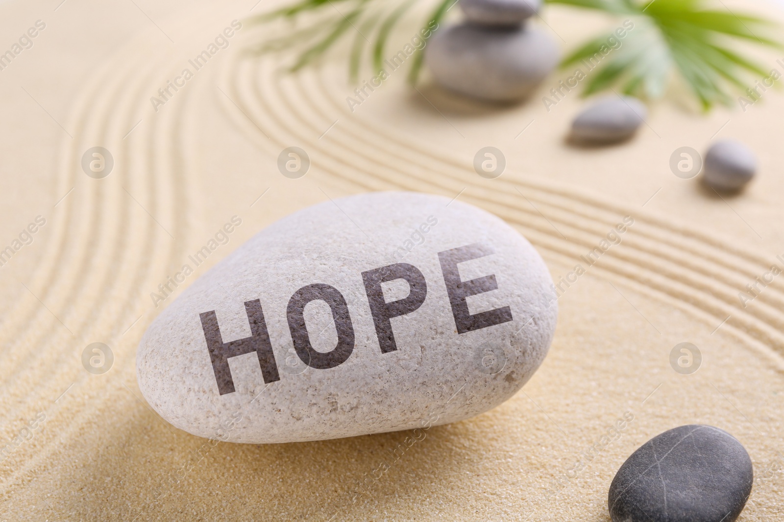 Image of Hope. Zen garden stones on sand with pattern, closeup