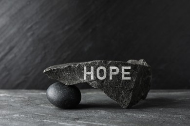 Image of Hope. Different stones on grey textured background.