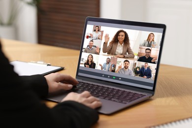 Business meeting. Woman using laptop during online video chat at table, closeup