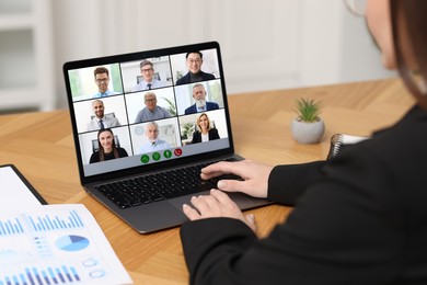 Image of Business meeting. Woman using laptop during online video chat at table, closeup