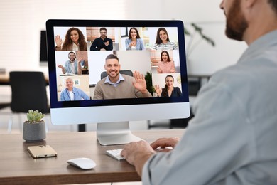 Image of Business meeting. Man using computer during online video chat at table, closeup