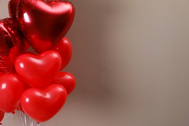 Photo of Bunch of heart shaped balloons for Valentine's day celebration on beige background, closeup. Space for text