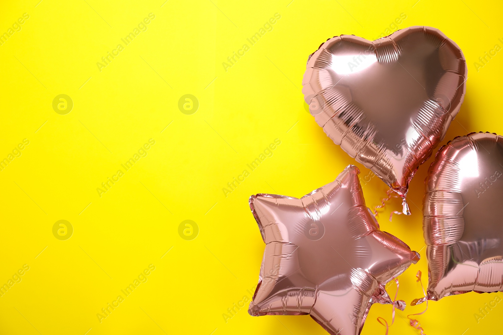 Photo of Pink balloons on yellow background, flat lay. Space for text