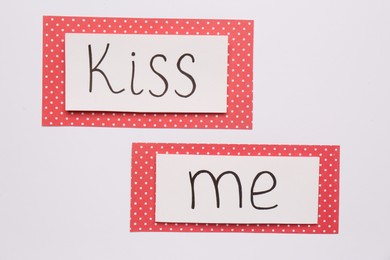 Photo of Cards with phrase Kiss me on white background, top view