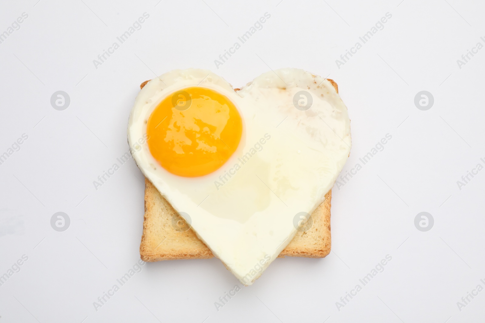 Photo of Tasty fried egg in shape of heart with toast isolated on white, top view