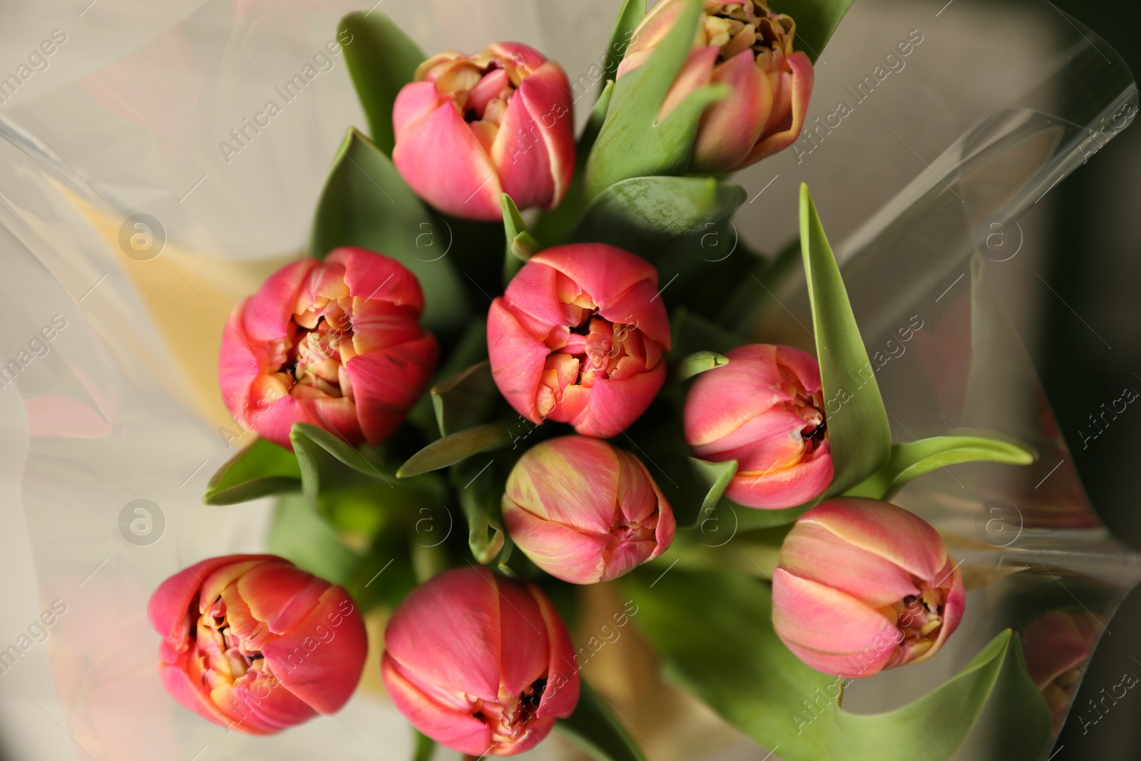 Photo of Beautiful bouquet of tulips on blurred background, top view