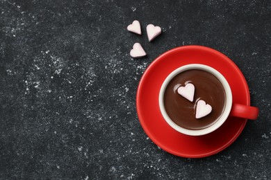 Photo of Cup of hot chocolate with heart shaped marshmallows on grey table, top view. Space for text