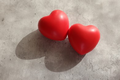 Photo of Two decorative hearts on gray textured table, above view