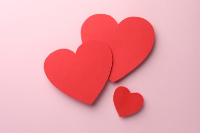 Photo of Paper hearts on pink background, flat lay