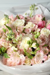 Photo of Beautiful bouquet of fresh flowers near wall, closeup