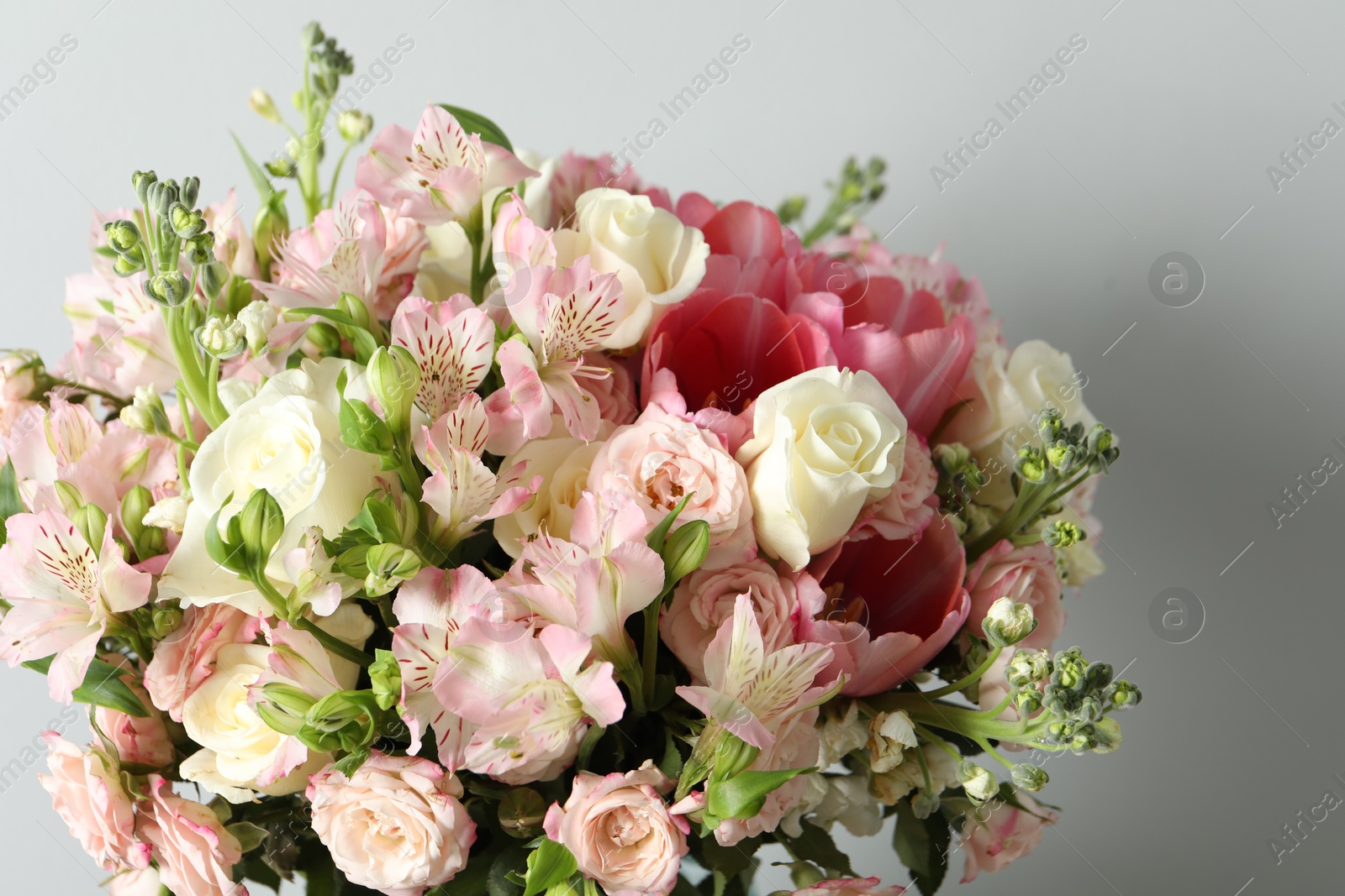 Photo of Beautiful bouquet of fresh flowers on light background, closeup