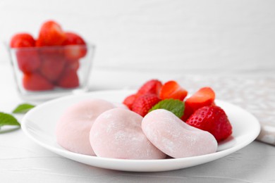 Photo of Delicious mochi and strawberries on white table, closeup