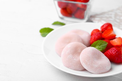 Photo of Delicious mochi and strawberries on white table, closeup