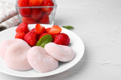 Photo of Delicious mochi and strawberries on white table, closeup