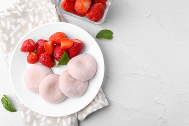 Photo of Delicious mochi and strawberries on white table, top view. Space for text