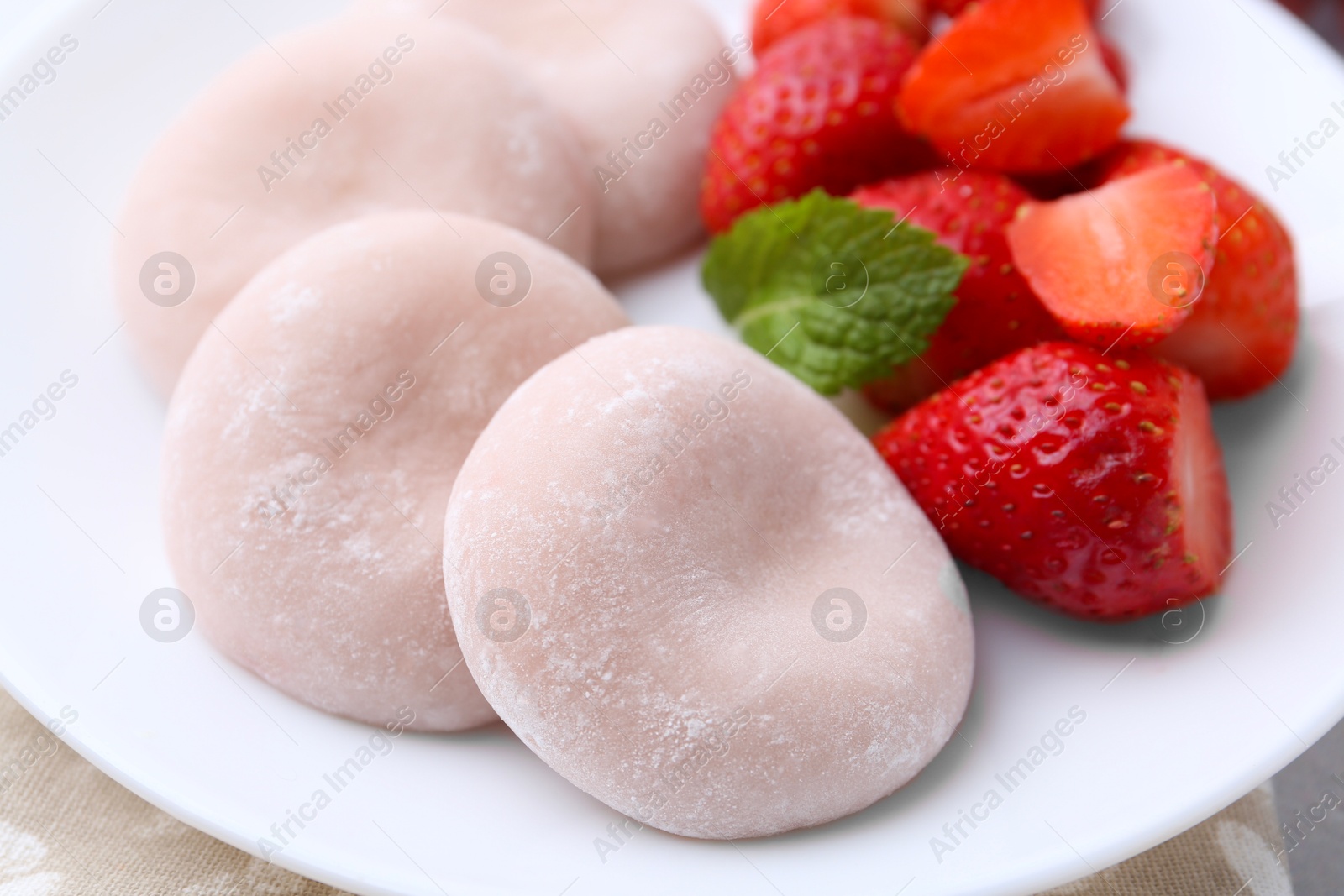 Photo of Delicious mochi and strawberries on table, closeup