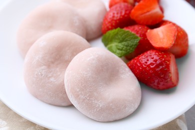 Photo of Delicious mochi and strawberries on table, closeup