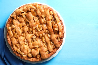 Photo of Homemade apple pie on light blue wooden table, top view. Space for text