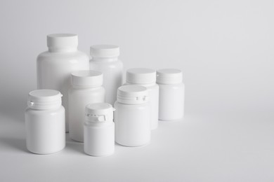 Photo of Many plastic medical bottles on white background, space for text