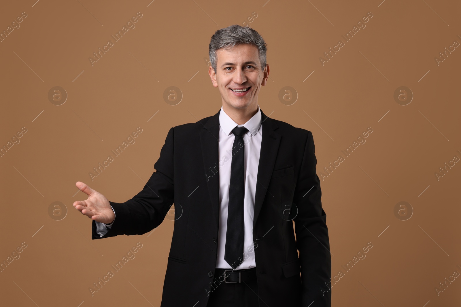 Photo of Portrait of businessman in jacket on brown background