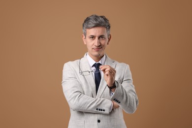 Photo of Portrait of businessman with glasses on brown background