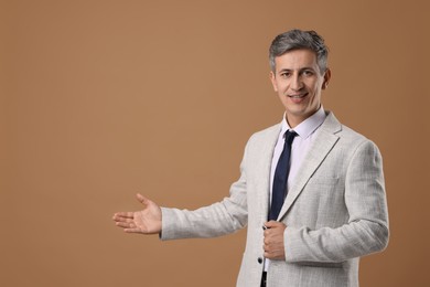 Photo of Portrait of businessman in jacket on brown background, space for text