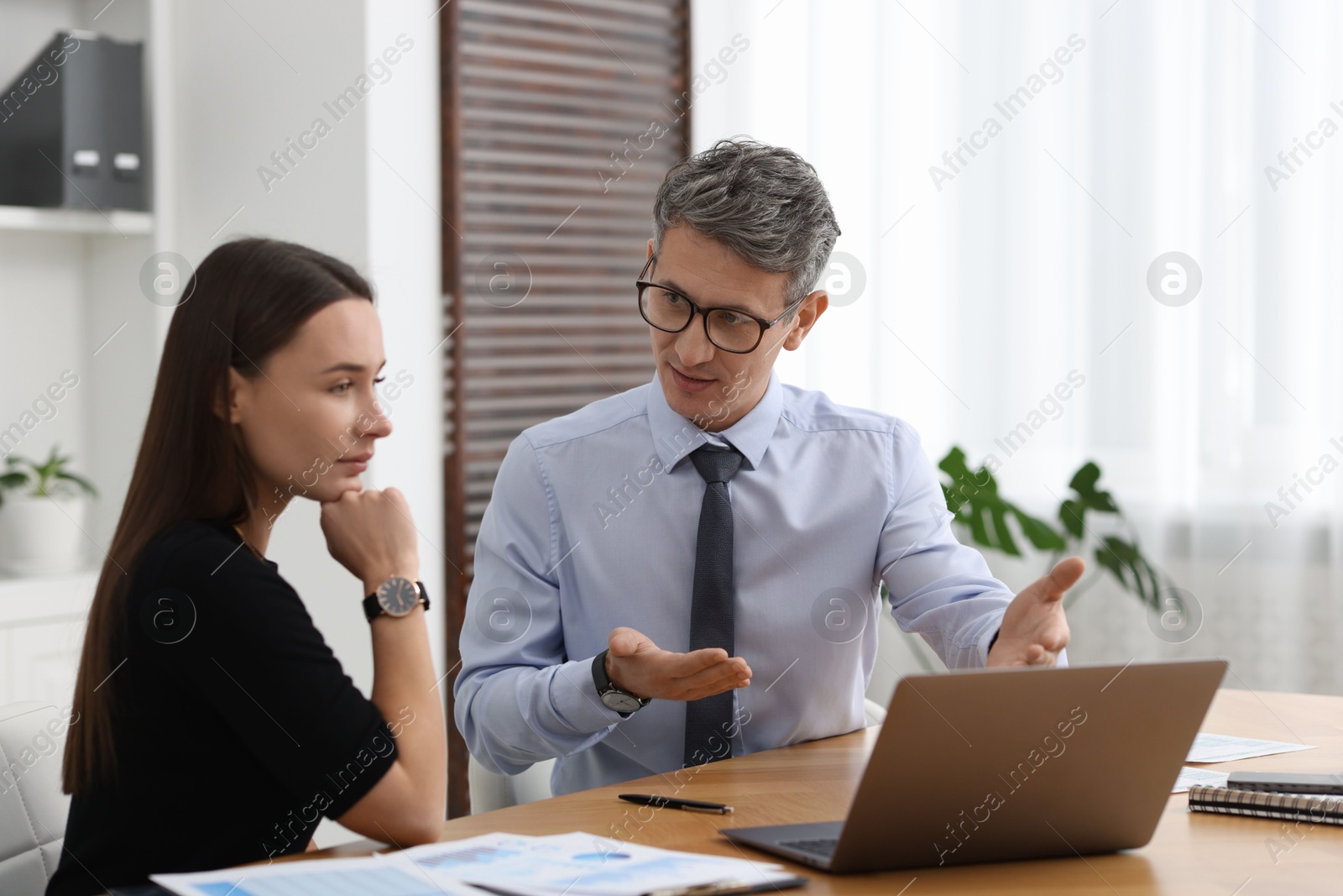 Photo of Coworkers working together at table in office