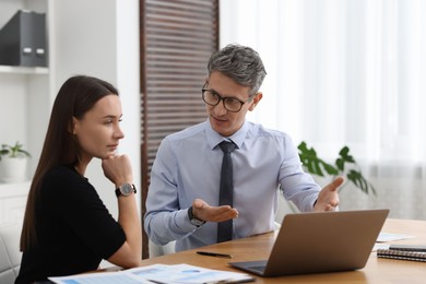 Photo of Coworkers working together at table in office