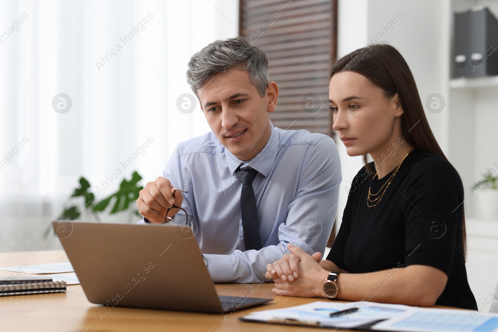 Photo of Coworkers working together at table in office