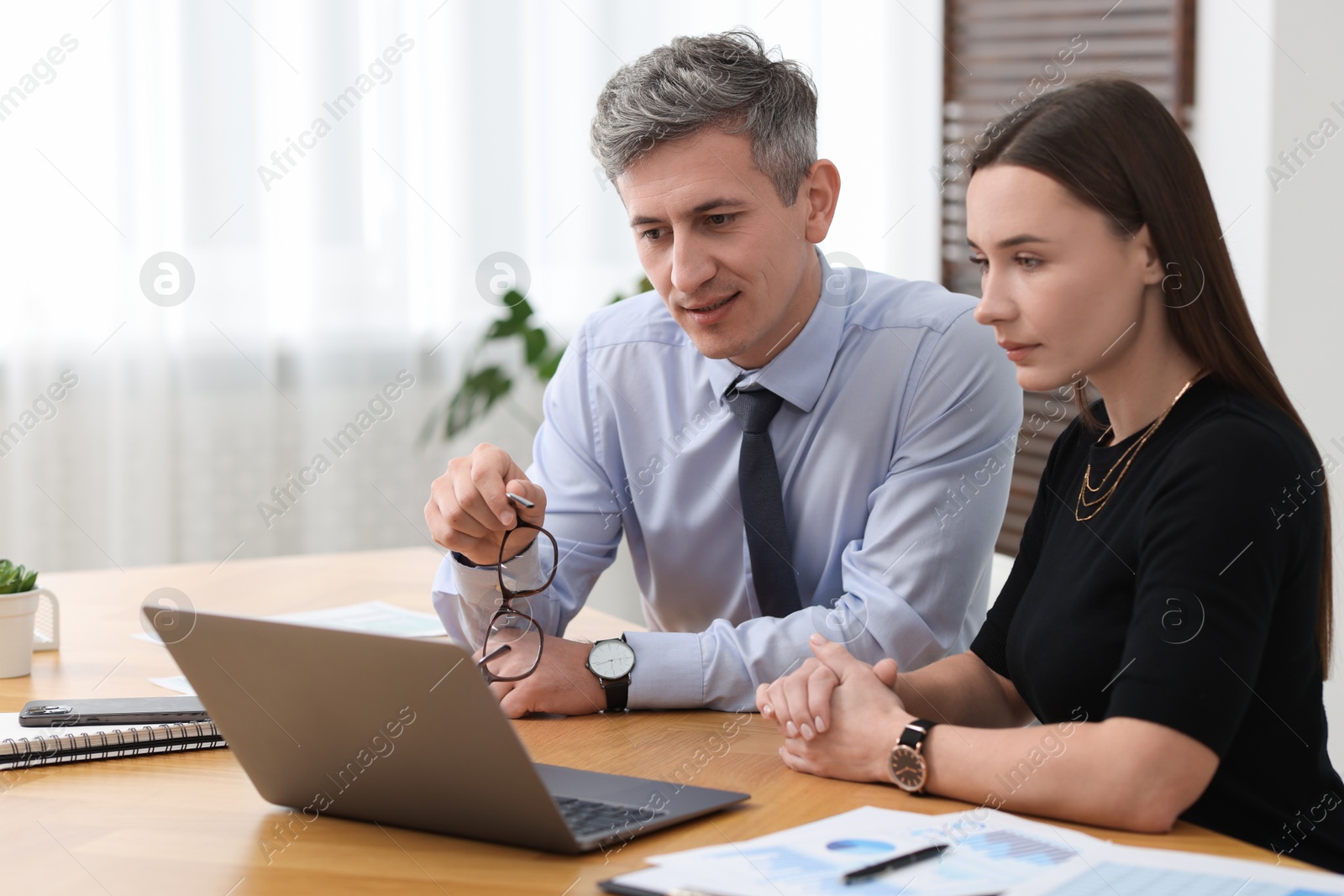 Photo of Coworkers working together at table in office