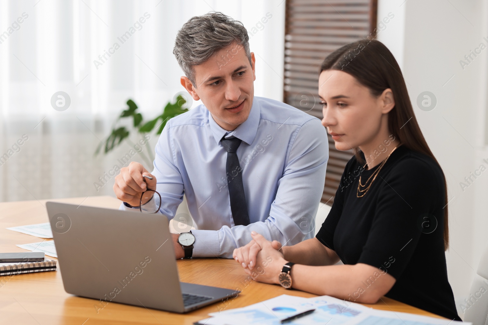 Photo of Coworkers working together at table in office