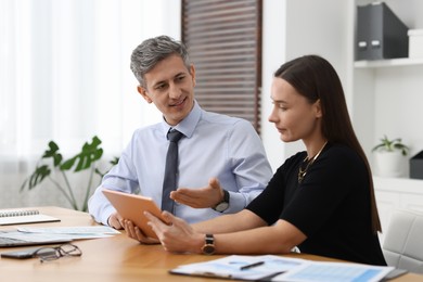 Coworkers with tablet working at table in office