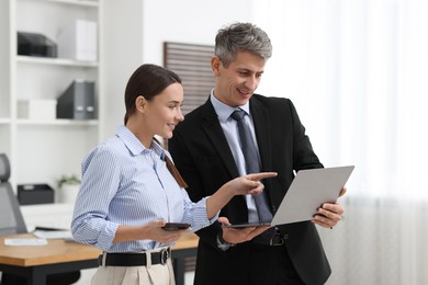 Photo of Coworkers with laptop working together in office