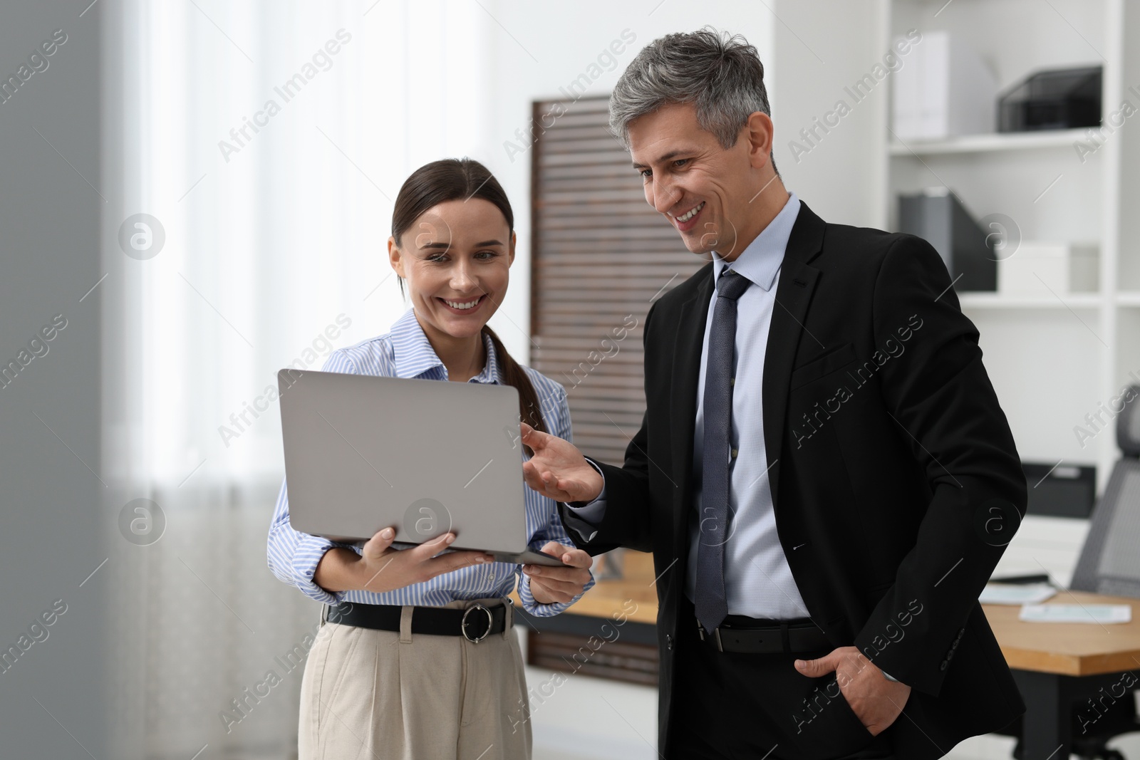 Photo of Coworkers with laptop working together in office