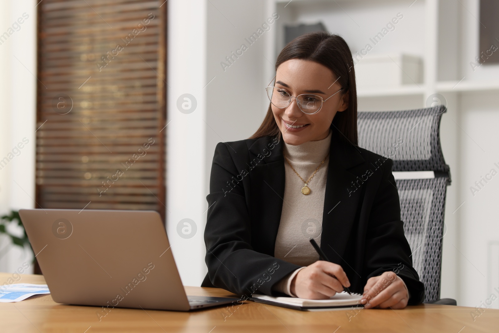 Photo of Businesswoman working at wooden table in office