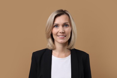 Photo of Portrait of businesswoman in jacket on beige background