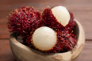 Photo of Delicious ripe rambutans in bowl on table, closeup