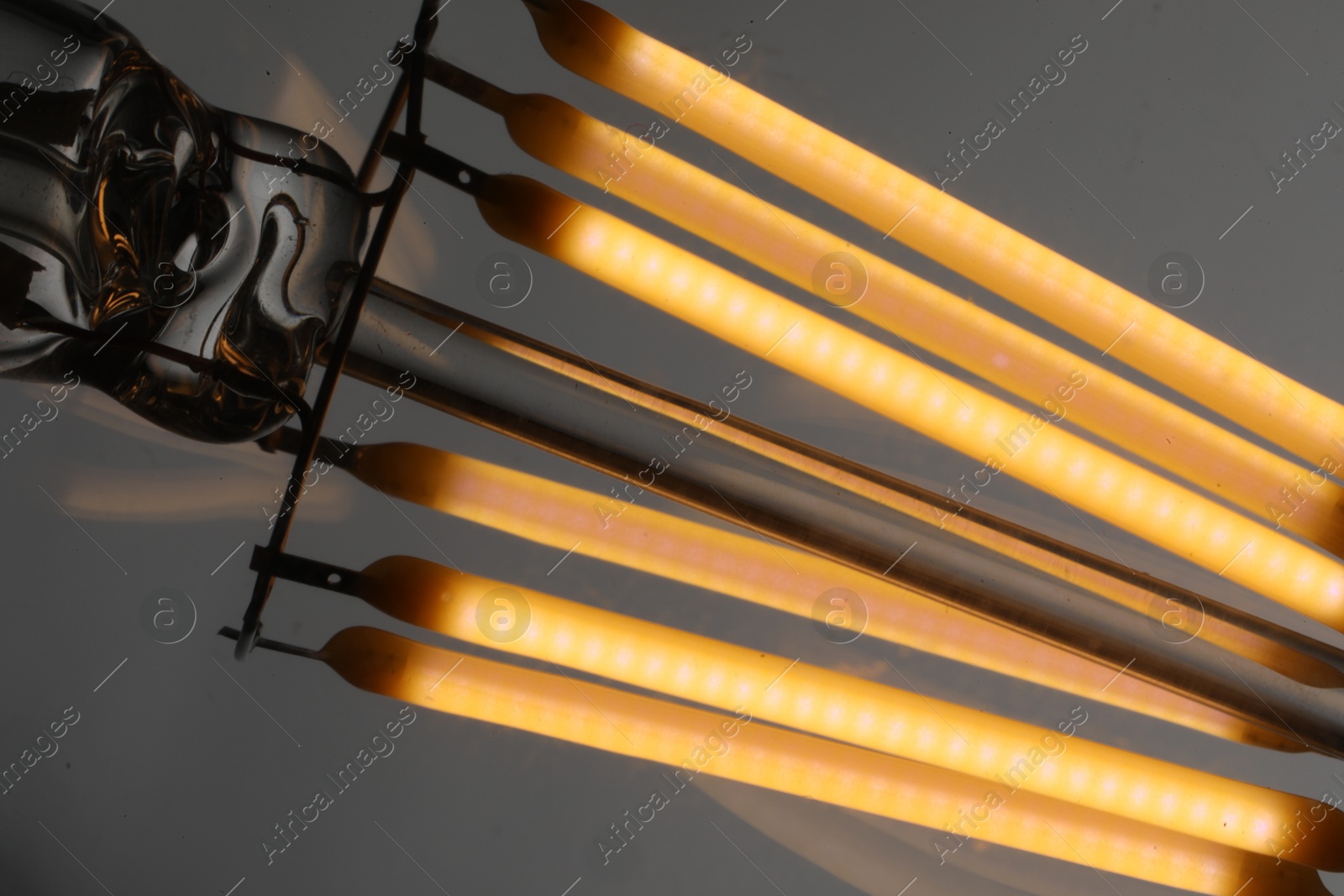 Photo of Glowing light bulb on grey background, closeup