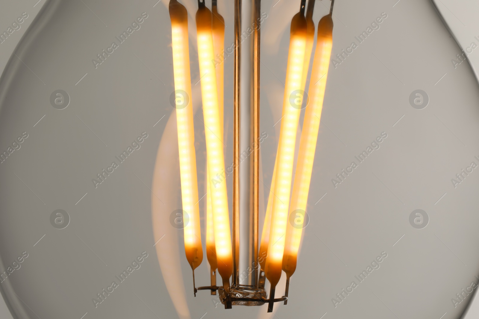 Photo of Glowing light bulb on grey background, closeup