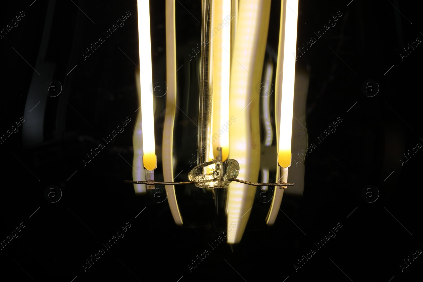 Photo of Glowing light bulb on dark background, closeup