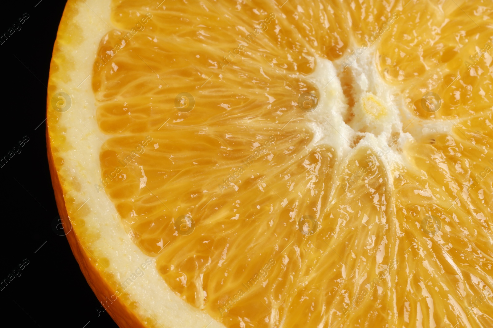 Photo of Fresh cut orange on black background, macro view