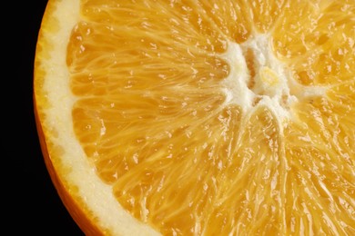 Photo of Fresh cut orange on black background, macro view