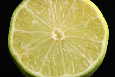 Photo of Half of fresh lime on black background, closeup