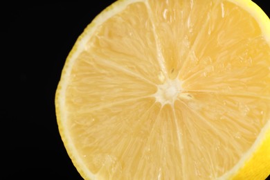 Photo of Half of fresh lemon on black background, closeup